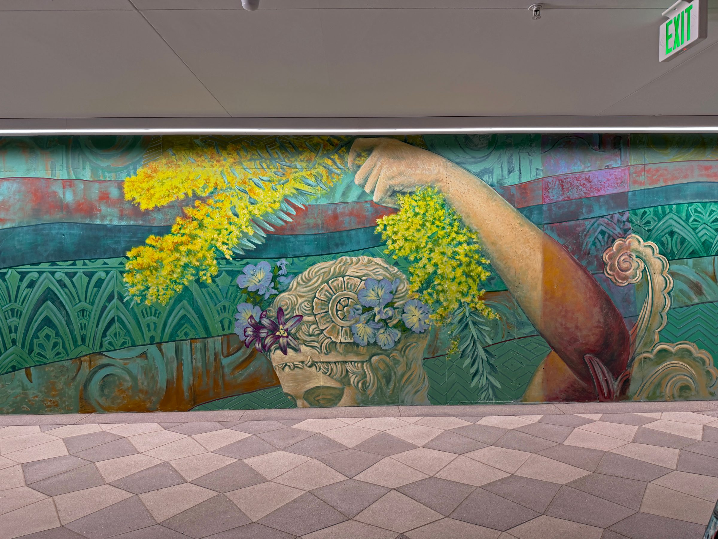 Section of the "Flourishing Structures" mural at Bloom on Third with an outstretched arm reaching through yellow mimosa and purple flowers