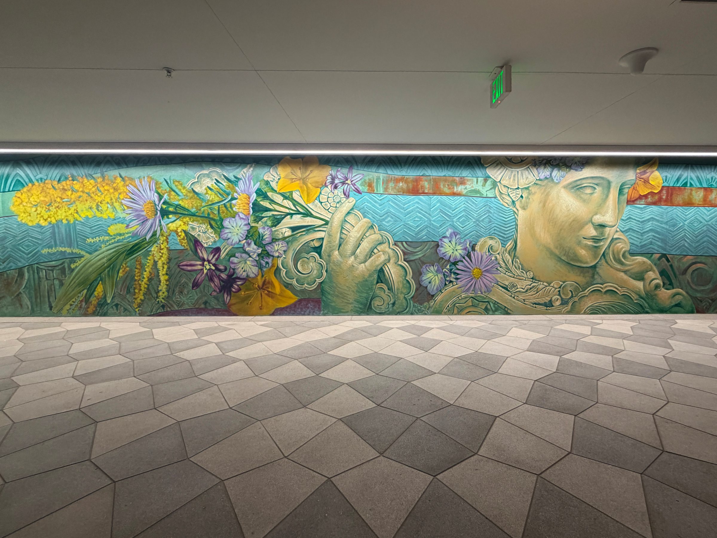 Bouquet section of the "Flourishing Structures" mural at Bloom on Third, with yellow mimosa, gold scrollwork and the sculpted face